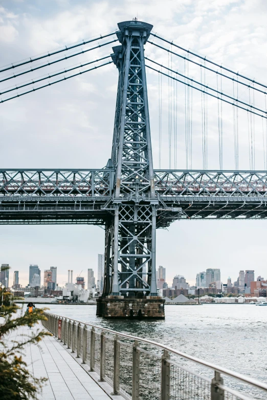 a bridge over a body of water with a city in the background, by Jacob Burck, unsplash contest winner, new york backdrop, steel archways, slide show, large tall