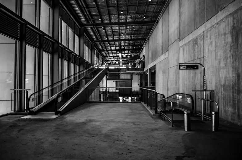a black and white photo of an escalator in a building, engineering bay, in australia, va-11 hall-a, voge photo