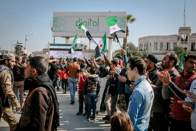 a group of people that are standing in the street, pexels, dau-al-set, real life photo of a syrian man, green flags, digital oth, placards