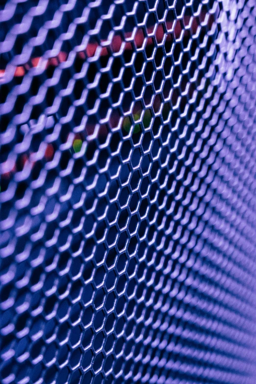 a close up of a chain link fence, by Matt Stewart, pexels, computer art, blue and purple lighting, perforated metal, high angle close up shot, looking partly to the left