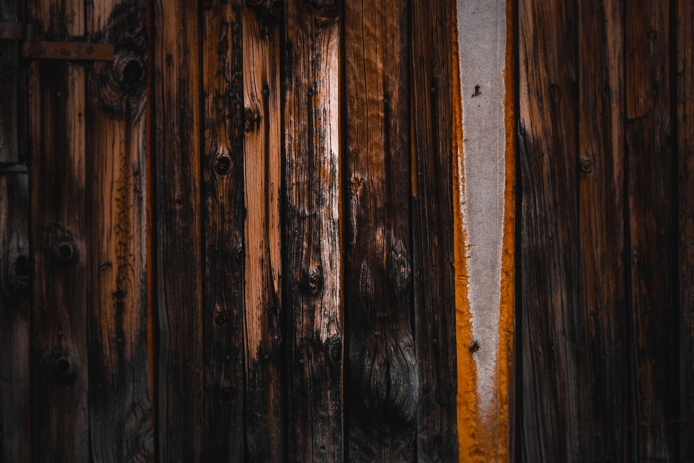 a close up of a wooden door on a building, by Kristian Zahrtmann, trending on pexels, dark grey and orange colours, cracked varnish, gradient brown to silver, wooden logs