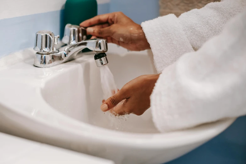 a person washing their hands in a bathroom sink, by Julia Pishtar, trending on pexels, fan favorite, hairy arms, water pipe, hydration