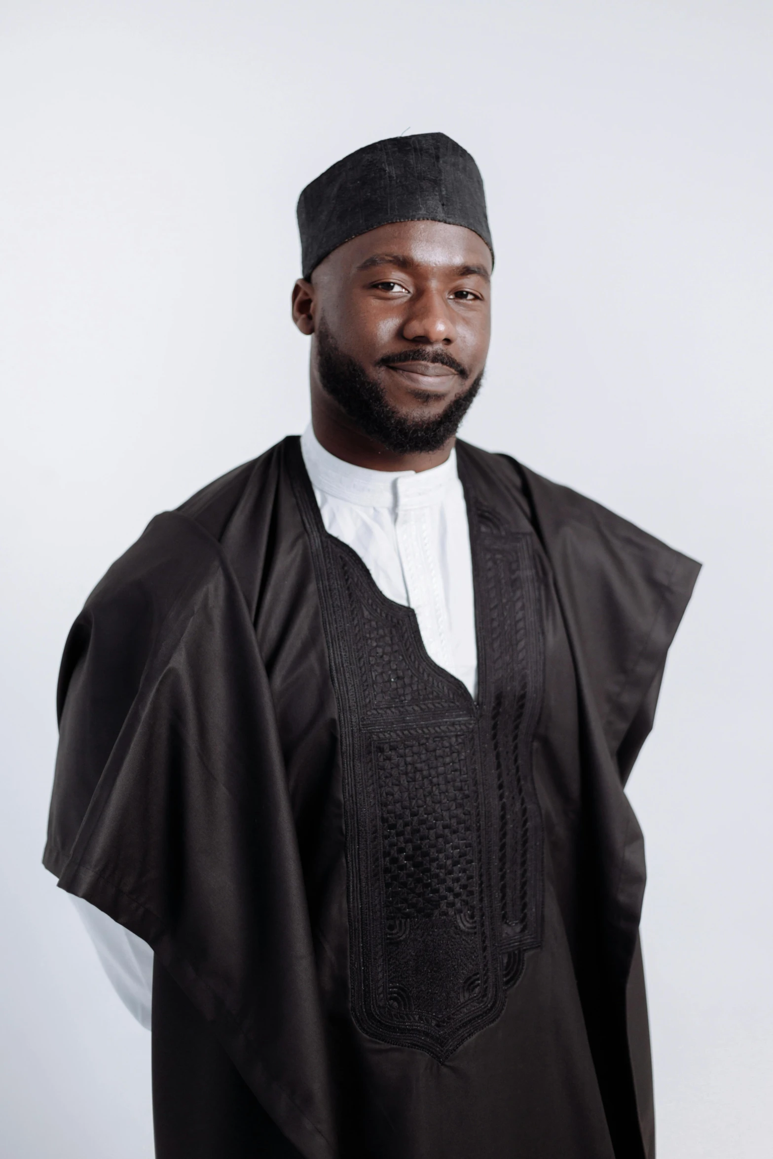 a man wearing a black and white outfit, inspired by Ras Akyem, wearing an academic gown, main colour - black, riyahd cassiem, open v chest clothes