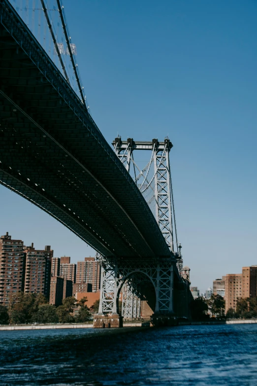 a view of a bridge over a body of water, by Jacob Burck, unsplash contest winner, harlem renaissance, tall metal towers, exterior, truss building, new york buildings