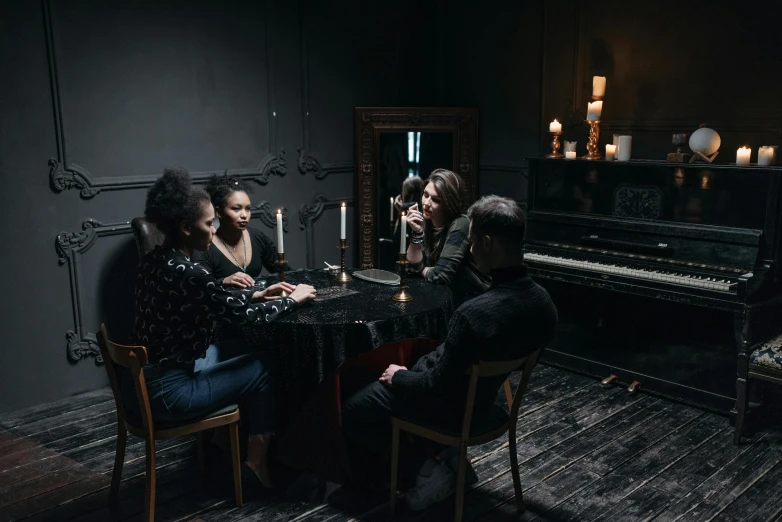 a group of people sitting around a table, eerie music, a seance, an escape room in a small, photoshoot