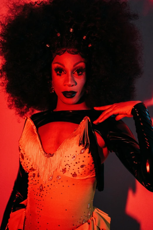 a woman with an afro is posing for a picture, an album cover, androgynous vampire, high red lights, sza, drag queen