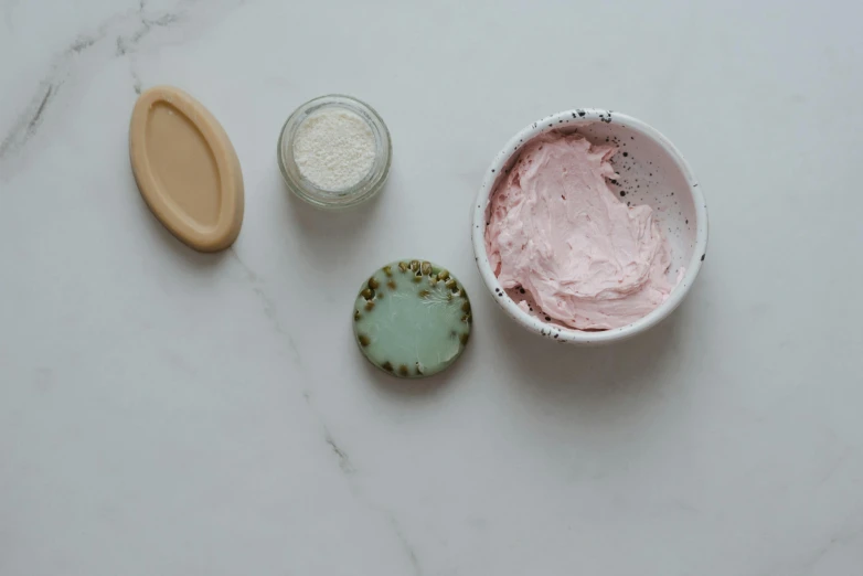 a bowl of ice cream sitting on top of a counter, a still life, inspired by Elsie Few, process art, pink concrete, skincare, cinnabar, soft pads