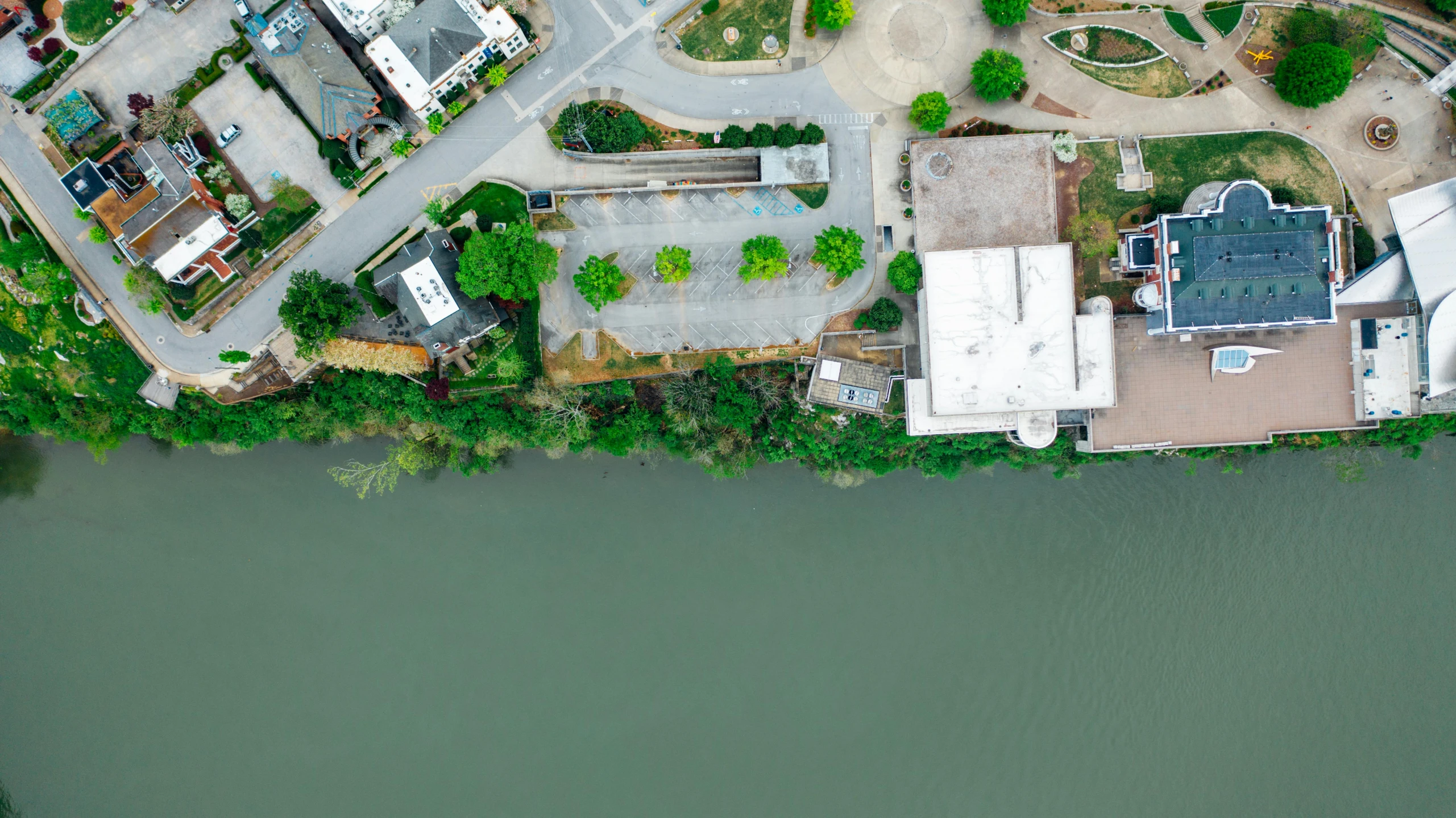 an aerial view of a neighborhood next to a river, unsplash, realism, building cover with plant, high resolution photo, low-angle shot, modeled