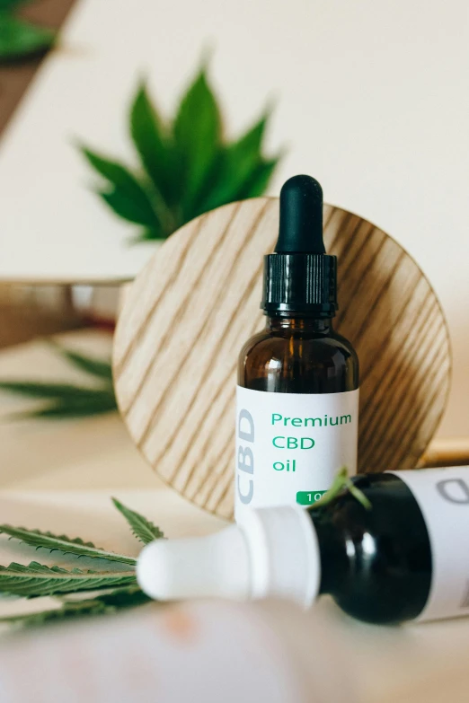 a bottle of cbd oil sitting on top of a table, trending on pexels, process art, potted plants, premium, melbourne, a wooden