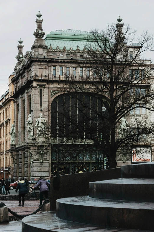 a large building with a fountain in front of it, a photo, inspired by Cornelis Engebrechtsz, art nouveau, shop front, stockholm city, from the distance, looking across the shoulder