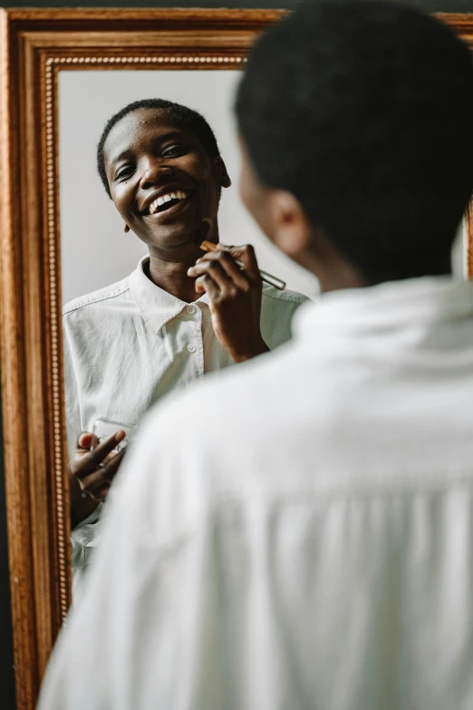 a man brushing his teeth in front of a mirror, pexels contest winner, photo of a black woman, with an elegant smile, androgynous male, lightly dressed