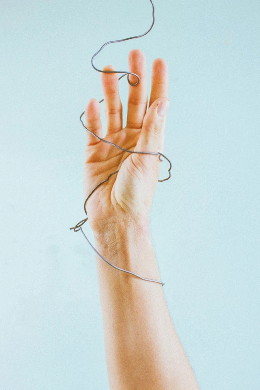 a person holding a string in their hand, by Nina Hamnett, jagged spiraling shapes, wire management, tendons, promo image