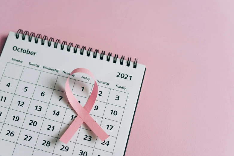 a calendar with a pink ribbon on it, happening, warts, thumbnail, covid, biological