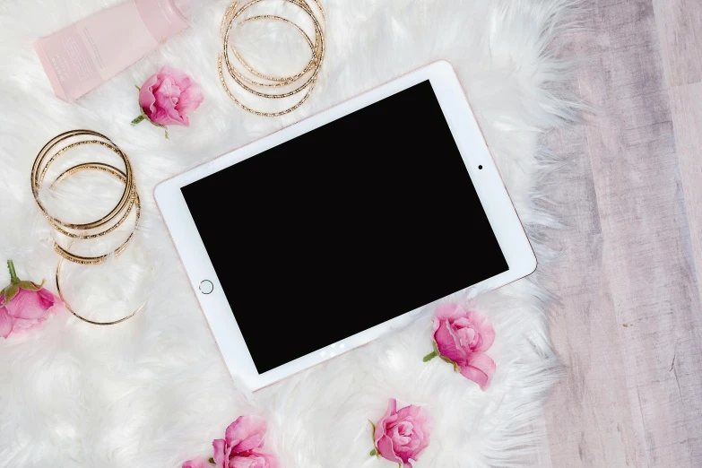 a tablet computer sitting on top of a white fur covered floor, by Julia Pishtar, trending on pexels, romanticism, pink accents, floral bling, ipad pro, background image