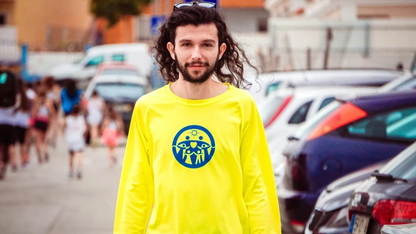 a man with long hair wearing a yellow shirt, inspired by Václav Brožík, lyco art, wearing a volleyball jersey, long sleeve, fluo colors, street clothing