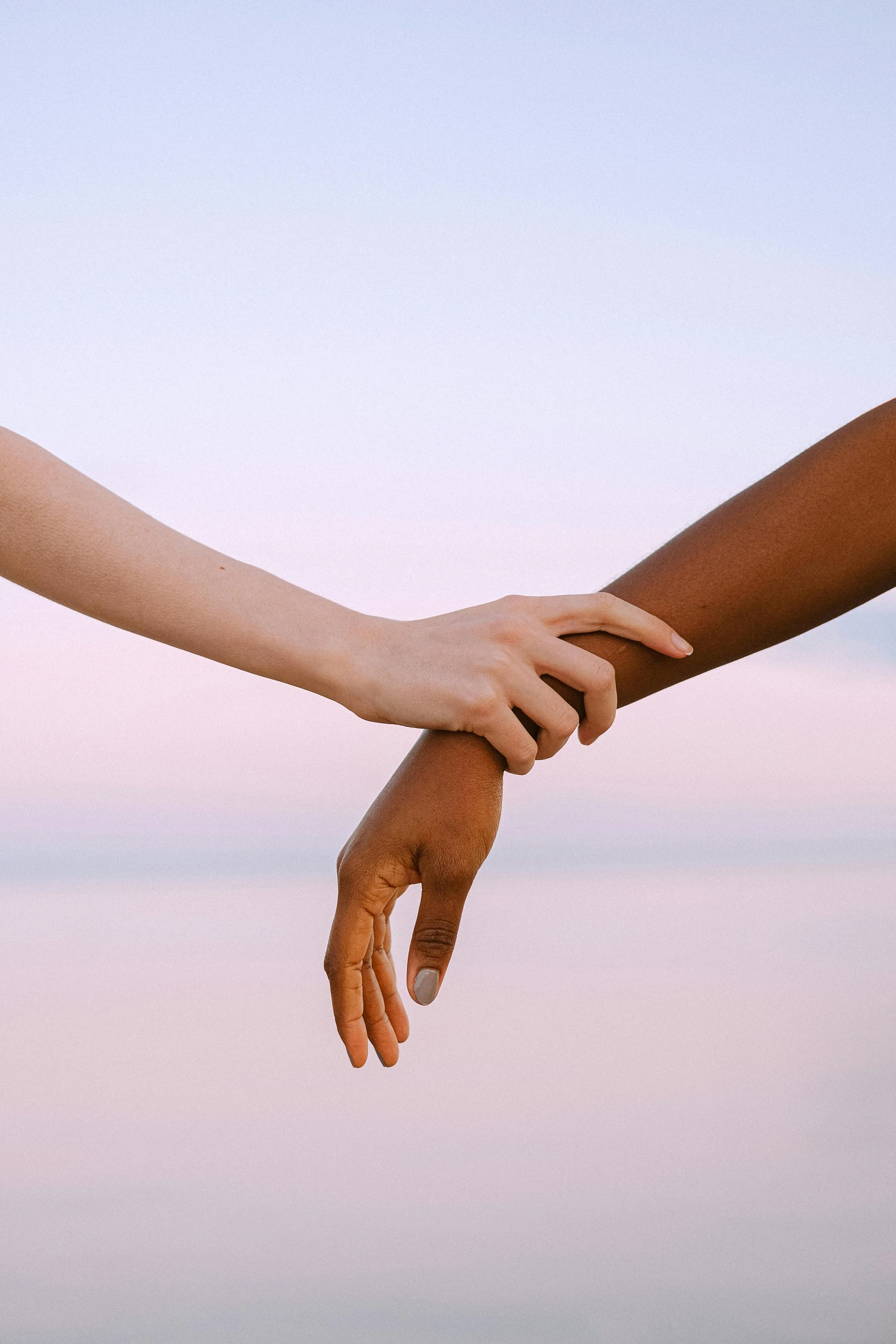 two people holding hands in front of a body of water, by Arabella Rankin, gradient brown to white, varying ethnicities, (golden hour), crossed arms