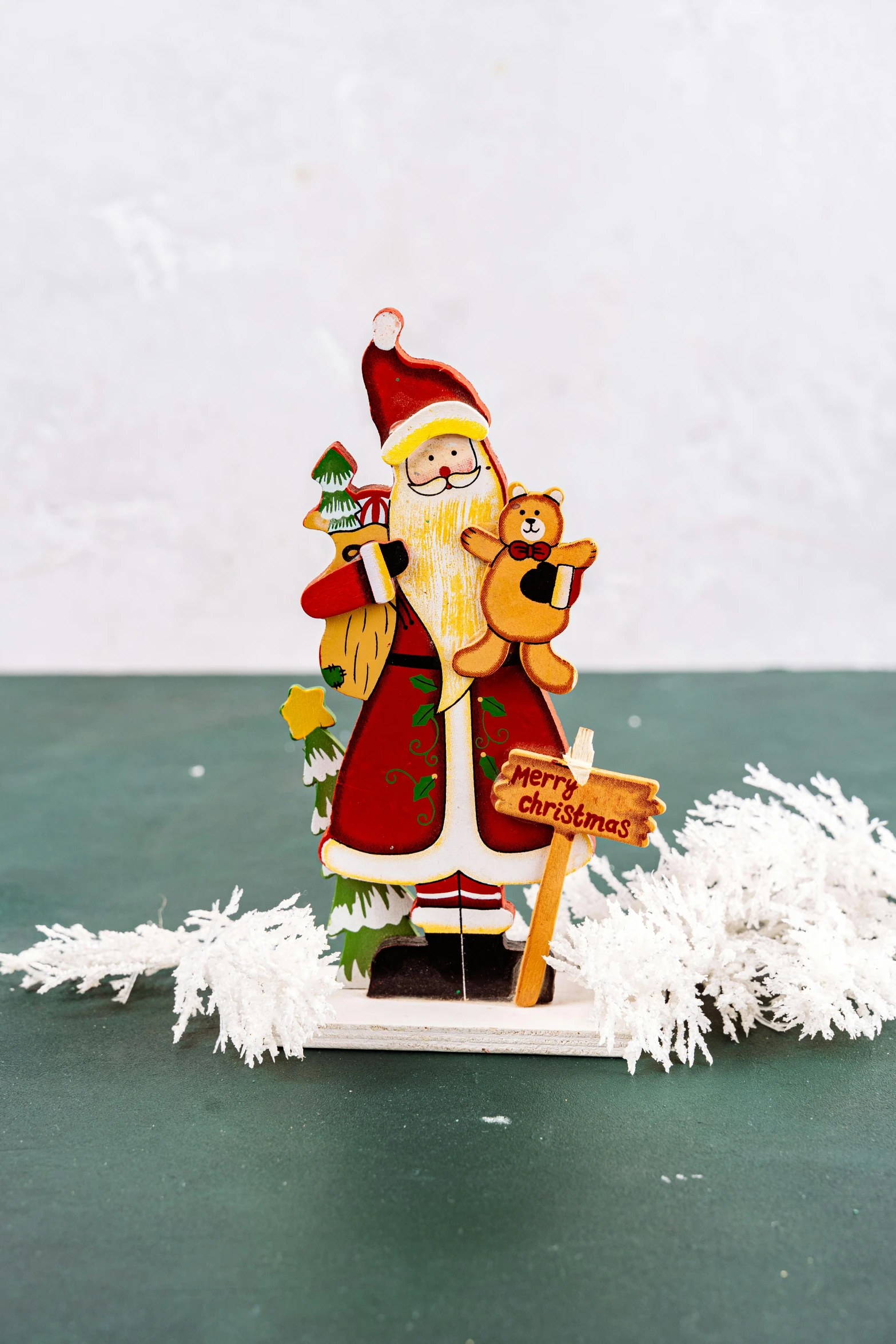 a christmas ornament sitting on top of a table, inspired by Ernest William Christmas, folk art, santa, diecut, with a wooden stuff, standing upright
