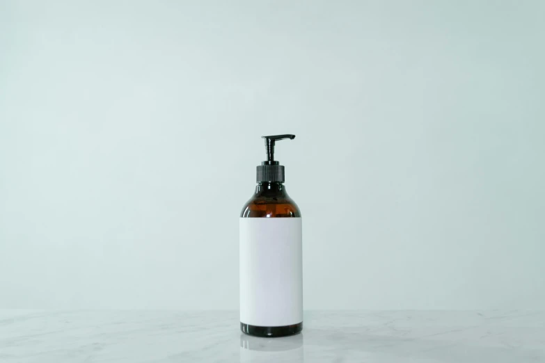 a bottle of liquid sitting on top of a table, pexels, private press, skincare, brown and white color scheme, 1 6 x 1 6, no - text no - logo