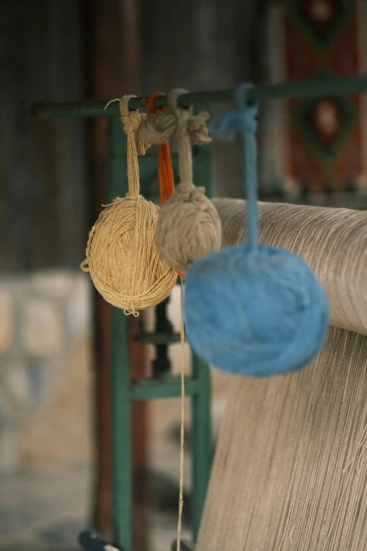 a bunch of balls of yarn hanging from a rack, by Yasushi Sugiyama, arts and crafts movement, bhutan, slide show, mill, rear-shot