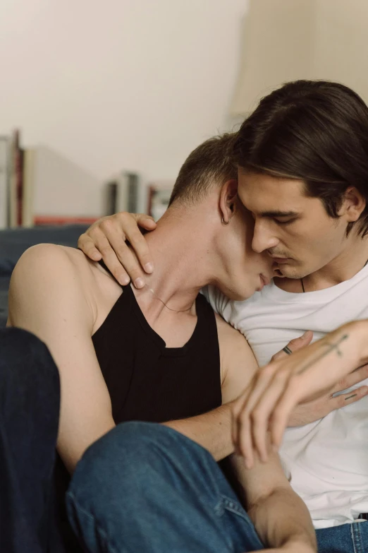 a couple of men sitting on top of a couch, reddit, bauhaus, lesbian embrace, official screenshot, thin young male, medium close shot
