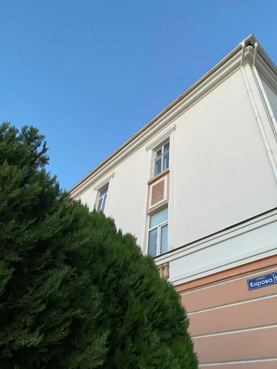 a building with a street sign in front of it, instagram, danube school, profile image, extra details, balcony, bushes in the background