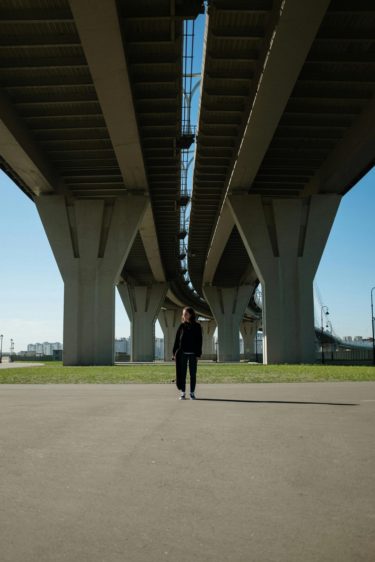 a person walking under a bridge with an umbrella, an album cover, unsplash, happening, concrete pillars, ilya kushinov, portrait of tall, official music video