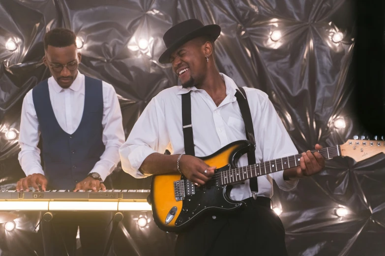 a couple of men standing next to each other playing musical instruments, happening, jamal campbell, playing electric guitar, profile image, ( ( theatrical ) )