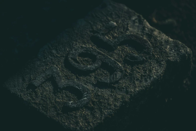 a rock that has some writing on it, an album cover, unsplash, cast iron material, dark runes, iso 800, anon 5 0 mm