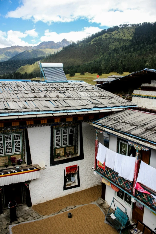 a house in the mountains with clothes hanging out to dry, flickr, cloisonnism, in a rooftop, square, white wall complex, exterior photo