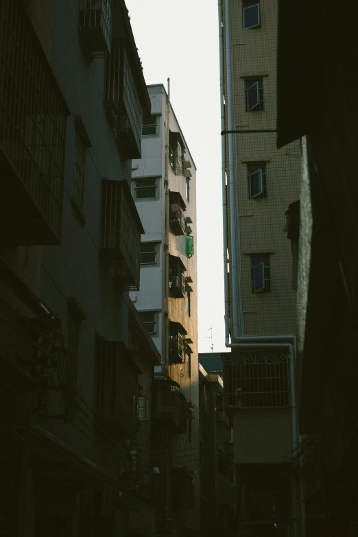 a couple of tall buildings sitting next to each other, inspired by Elsa Bleda, unsplash contest winner, old jeddah city alley, low detail, streets of salvador, view from the side”