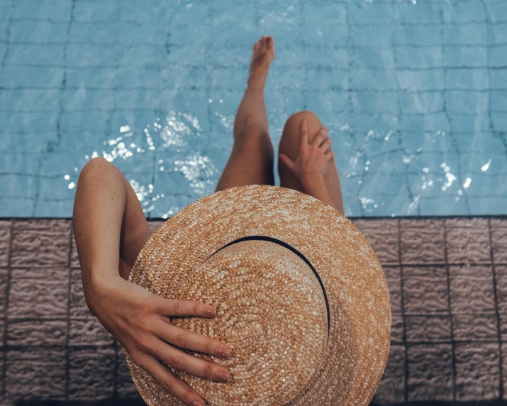 a woman in a straw hat sitting next to a swimming pool, pexels contest winner, thumbnail, multiple stories, bare leg, teal aesthetic