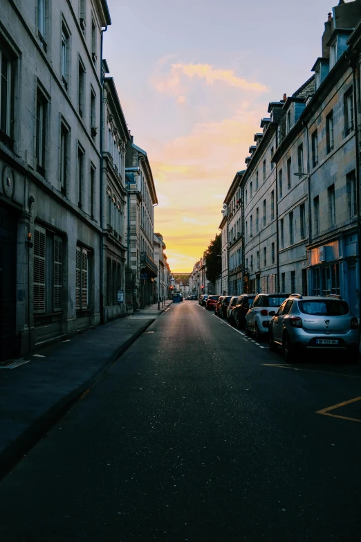 a street lined with parked cars next to tall buildings, by Raphaël Collin, pexels contest winner, renaissance, nice sunset, french village exterior, northern france, gothic city streets behind her
