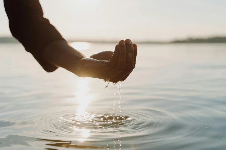 a person pouring water into a body of water, trending on unsplash, natural hands and arms, morning hour, fan favorite, blessing hands