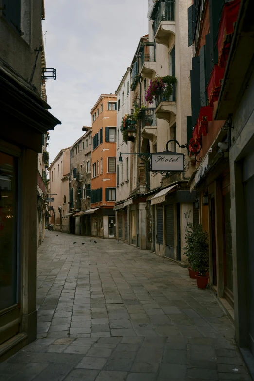 a narrow cobblestone street in a european city, an album cover, inspired by Quirizio di Giovanni da Murano, unsplash, renaissance, calm evening, bay, old shops, sparsely populated