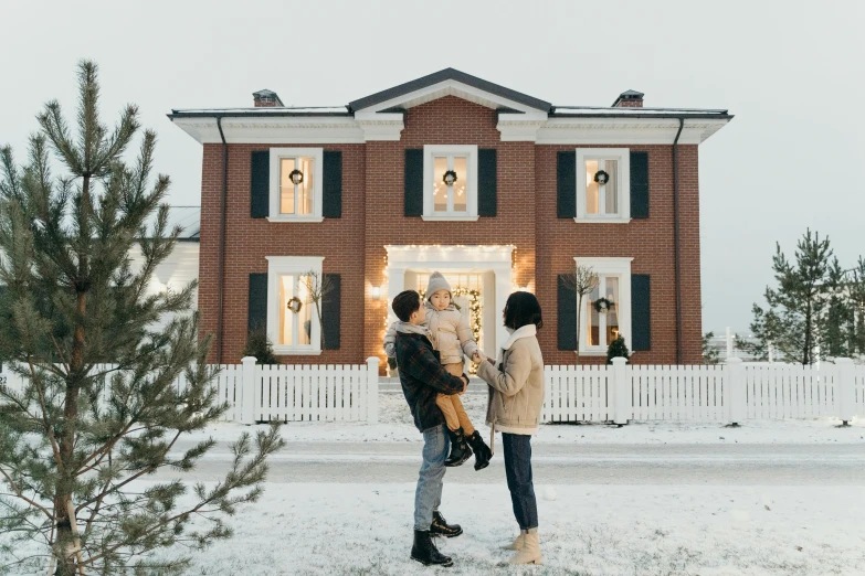 two people standing in front of a house in the snow, by Julia Pishtar, pexels contest winner, happy family, neo - classical style, mason, christmas