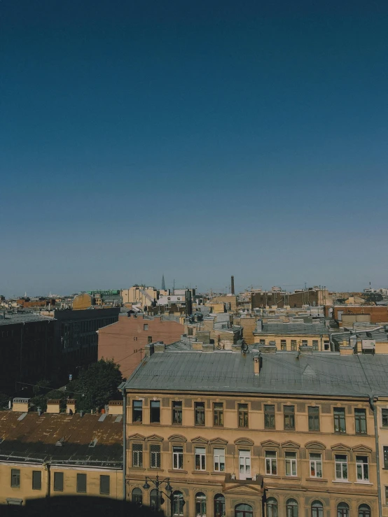 a large clock tower towering over a city, by Andrei Kolkoutine, ultrawide angle cinematic view, brown, low quality photo, roofs