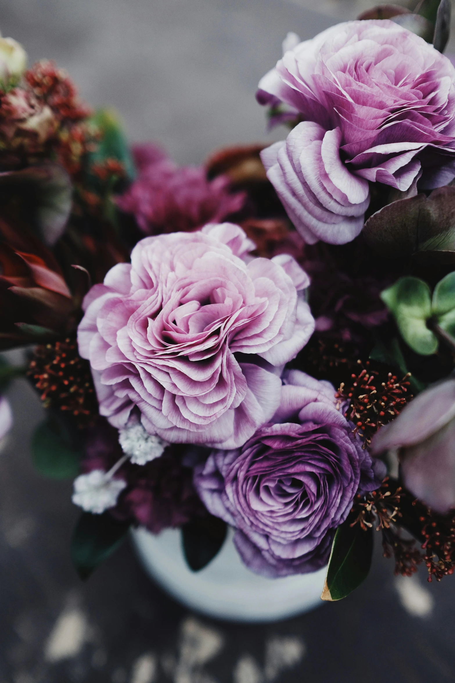 a vase filled with purple flowers on top of a table, by Elsie Few, unsplash, decorative roses, layered texture, intricate details. front on, seasonal