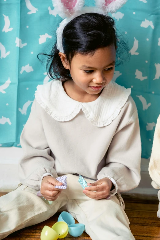 two little girls sitting on the floor playing with toys, inspired by Maurice Sendak, wearing sweatshirt, pleated skirt, white and teal garment, neutral colours