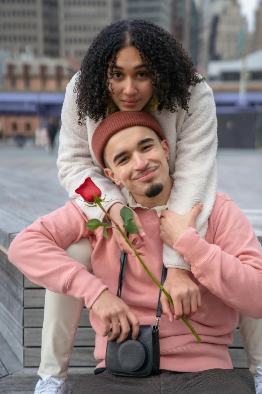 a man sitting on top of a woman holding a rose, trending on pexels, mixed race, dressed casually, promotional image, headshot