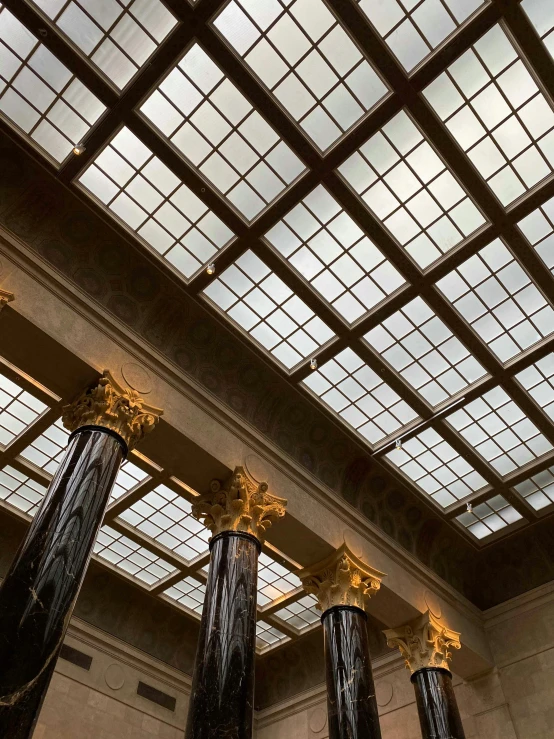 a group of pillars in a building with a skylight above them, by Greg Rutkowski, best photo