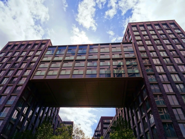 a very tall building with lots of windows, inspired by David Chipperfield, unsplash, sky bridge, kreuzberg, brown, steel archways