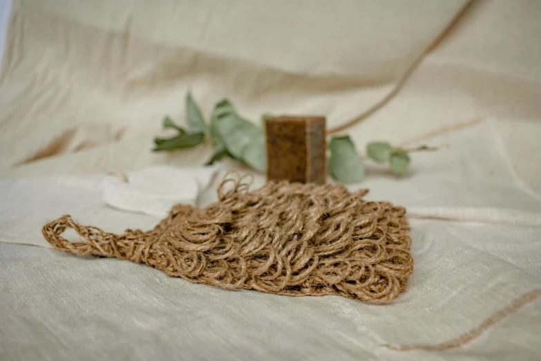 a pile of rope sitting on top of a table, an album cover, unsplash, brown resin, fine foliage lace, linen, celebration of coffee products