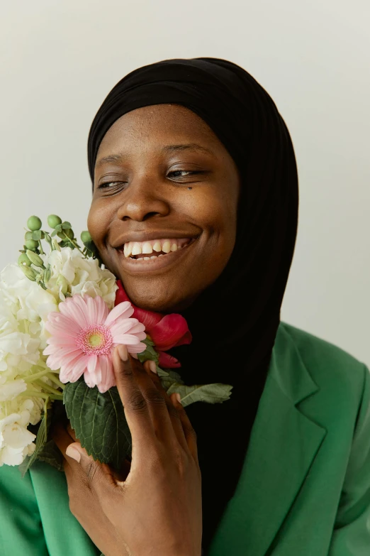 a woman in a green jacket holding a bouquet of flowers, hurufiyya, photo of a black woman, riyahd cassiem, with a happy expression, muslim
