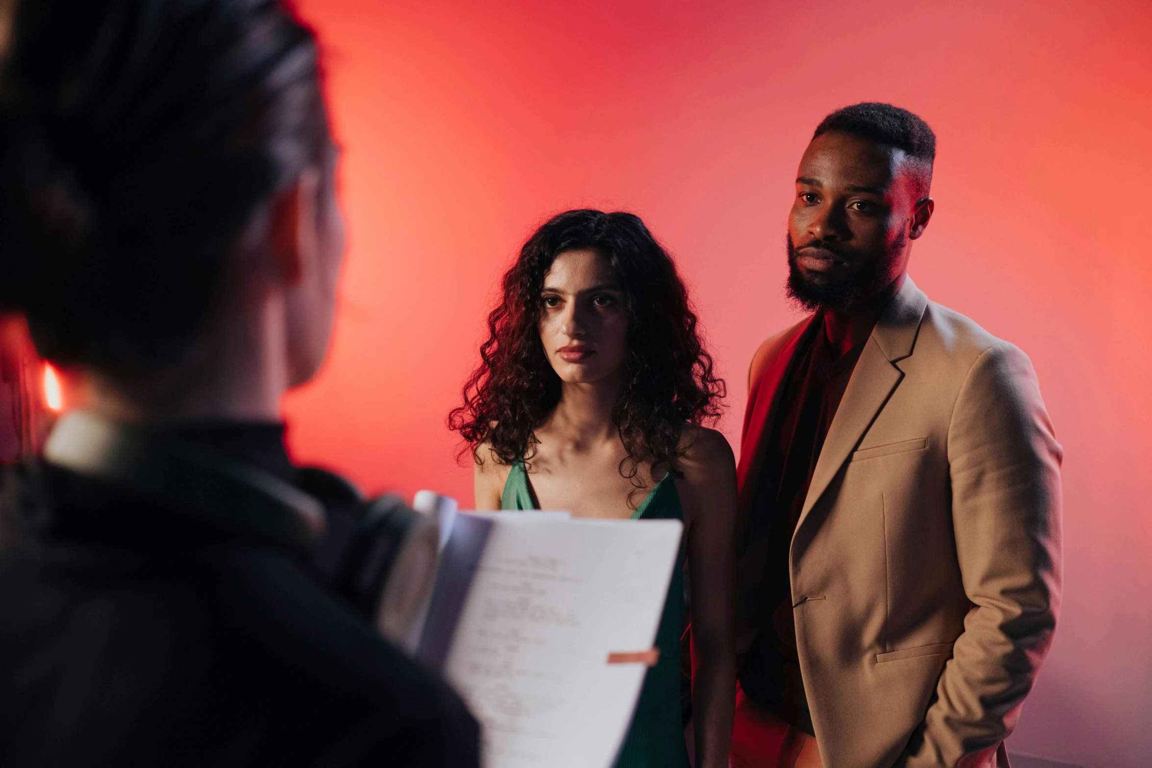 a man and a woman standing next to each other, pexels contest winner, serial art, meet the actor behind the scenes, cinematic red lighting, charli bowater and artgeem, person in foreground