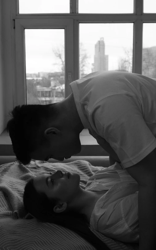 a man kissing a woman on top of a bed, a black and white photo, by Adam Marczyński, happening, bella poarch, seen from the side, in the early morning, late afternoon