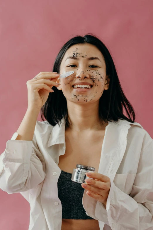 a woman holding a camera in front of her face, skincare, black tar particles, japanese collection product, smiling mask