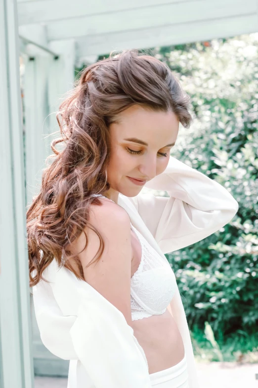 a woman in a white dress posing for a picture, hands in her hair, wearing bra, maternity feeling, wearing a robe