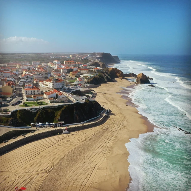 an aerial view of a beach next to the ocean, by Tom Wänerstrand, pexels contest winner, happening, portugal, square, quaint, profile image
