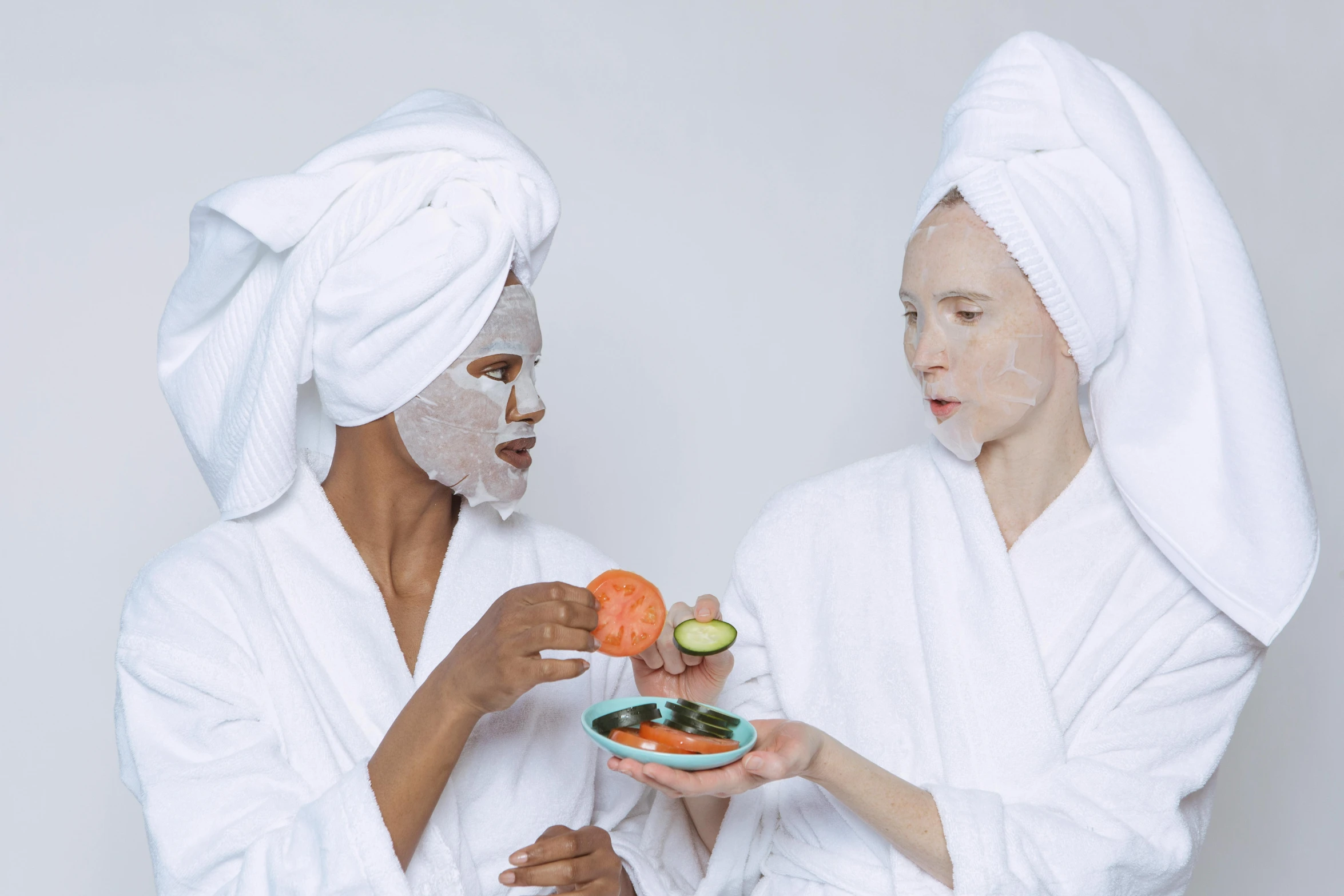 a couple of women standing next to each other, trending on pexels, renaissance, shower cap, candy treatments, white mask, offering a plate of food