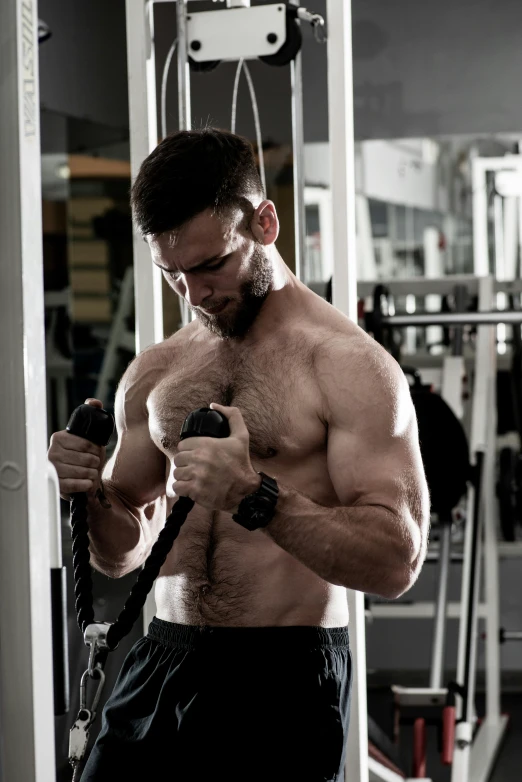a shirtless man holding a rope in a gym, a photo, by Adam Marczyński, hairy arms, hyper detailed, square, wearing tank top
